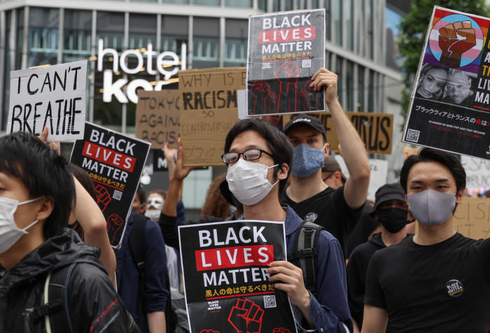 Protesters hold signs and chant slogans during a Black Lives Matters Peaceful March on June 14, 2020 in Tokyo, Japan.
