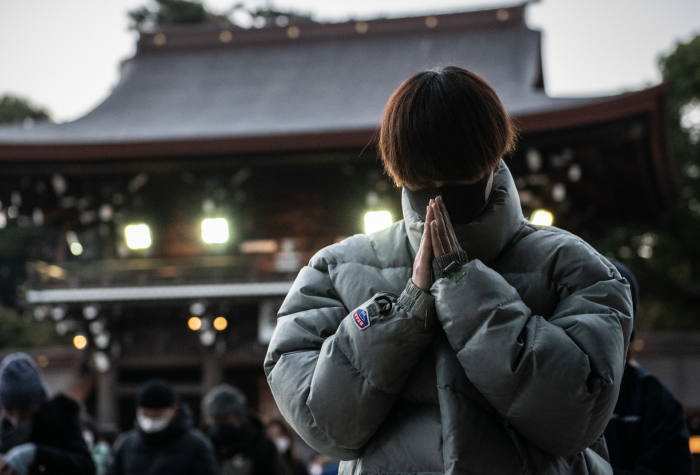 A man wearing a face mask prays for the new year at Meiji Shrine in Tokyo, Japan.