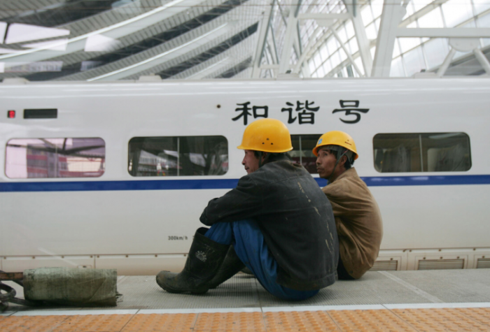 BEIJING, CHINA - Workers sit near a CRH (China Railway High-speed) "bullet train" at the Beijing South Railway Station under reconstruction.