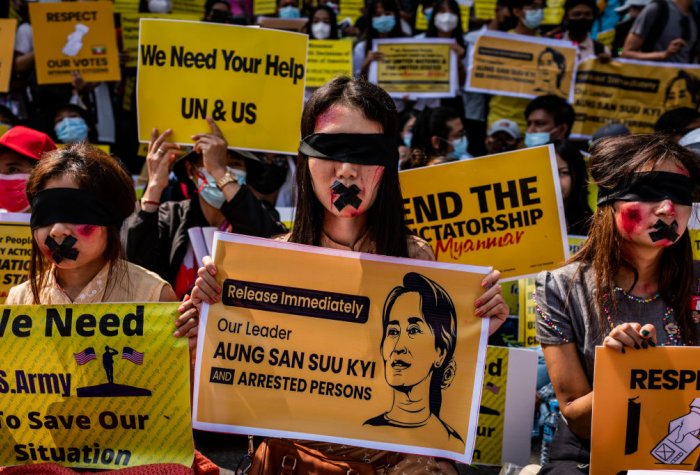 Protesters against the military coup in Myanmar hold banners.