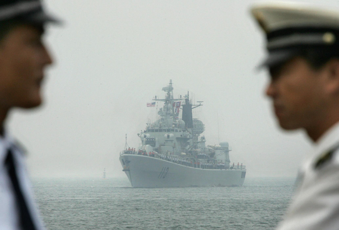 A naval ship in the South China Sea in the background fo two officers.