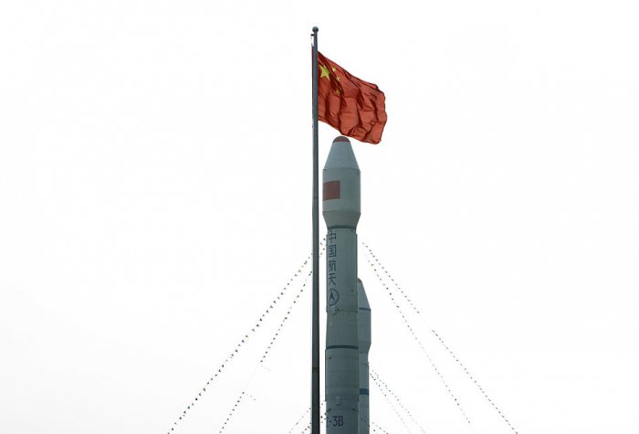 Chinese flag flying above orbital carrier rocket