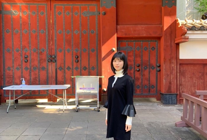 female student standing in front of Akamon in Japan