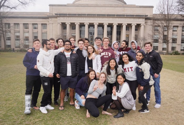 group of students taking a photo in front of a building