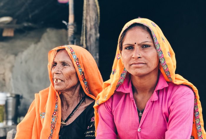 Two women sitting outdoor in Khidarpur Jadoo, Rajasthan, India.