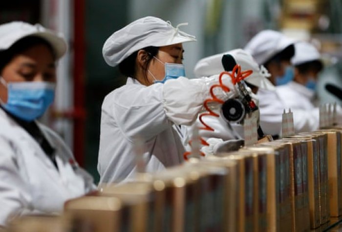 Workers on the assembly line in the packaging workshop of a liquor enterprise, Sihong county, Jiangsu province, China.