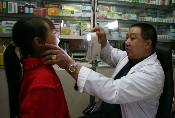 A doctor checks a young girl in a countryside clinic at Shihao Township on October 13, 2007 in Qijiang County of Chongqing Municipality, China.