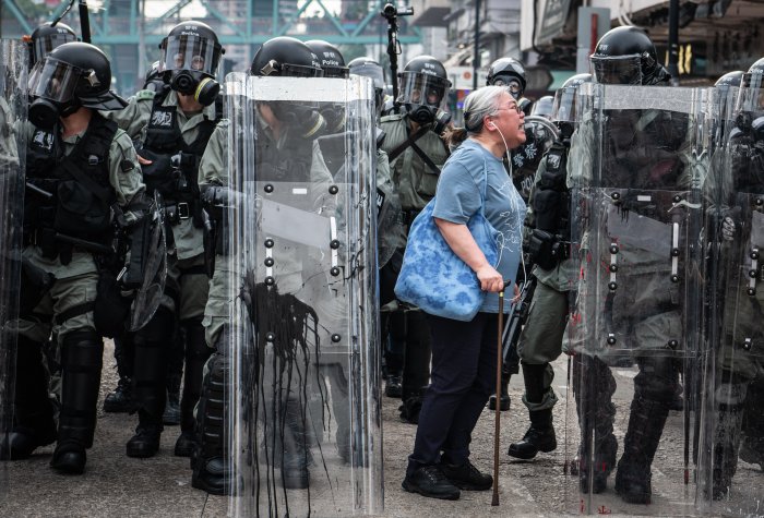 Woman shouts at police officers as they advance towards protesters in Hong Kong