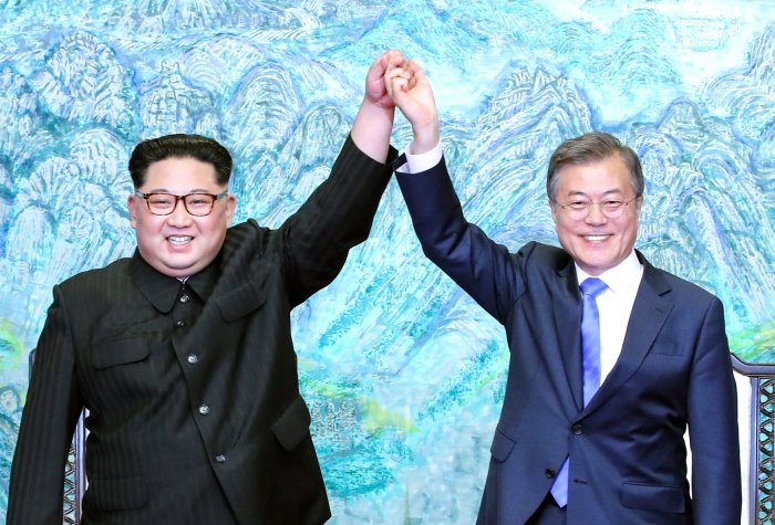 North Korean leader Kim Jong Un (L) and South Korean President Moon Jae-in (R) pose for photographs