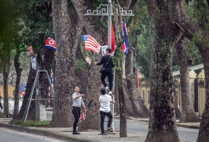 Workers remove the U.S flag from a display that was erected for the DPRK-USA summit, ahead of the arrival of North Korean leader Kim Jong-un at the Presidential Palace on March 1, 2019 in Hanoi, Vietnam
