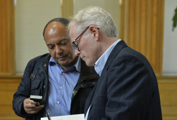 Ian Johnson signing a book for a community member.