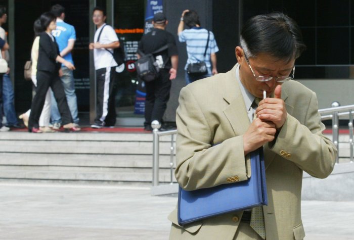 A man smokes in the street in Seoul, South Korea.
