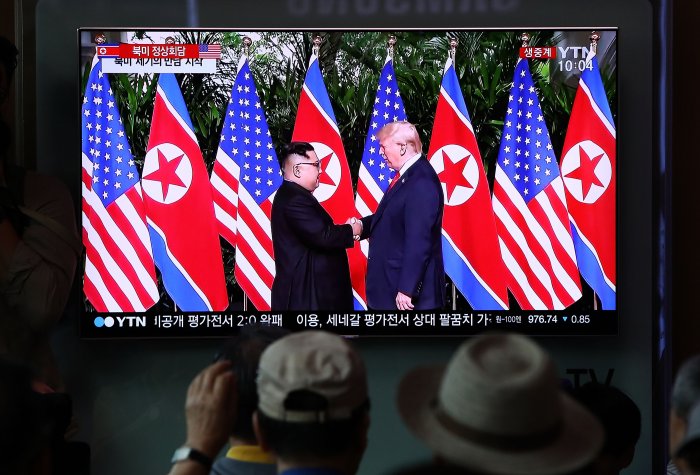 South Koreans watch on a screen reporting on the U.S. President Trump meeting with North Korean leader Kim Jong-un at the Seoul Railway Station on June 12, 2018 in Seoul, South Korea