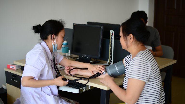 Doctor taking blood pressure and heart beat of patient.