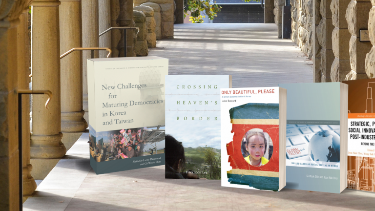 Covers of Korea Program books on the backdrop of Encina Hall colonnade, Stanford