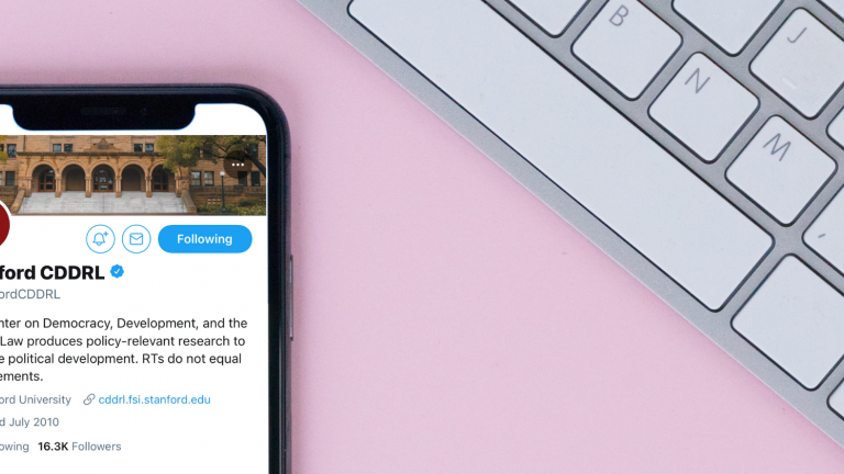 iPhone with CDDRL Twitter page on screen next to a keyboard on a pink background